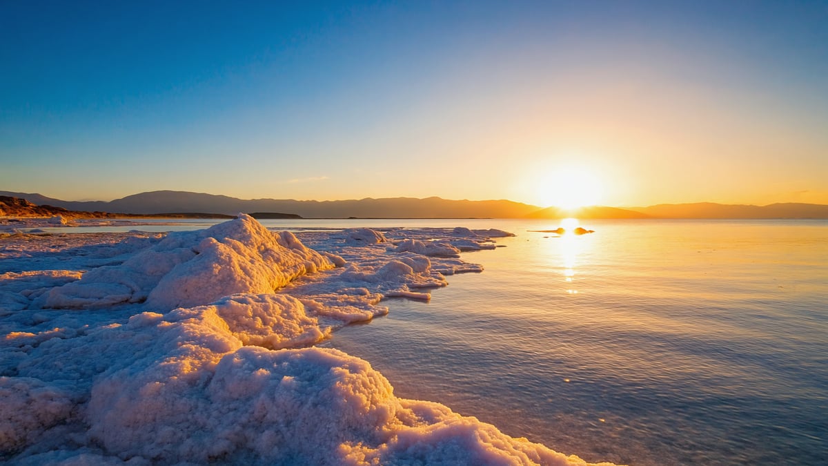 Dead Sea shoreline with salt formations and still water